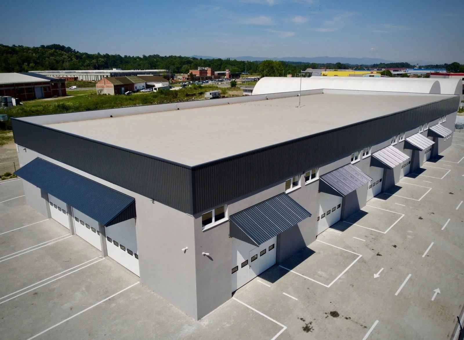 Industrijski kompleks sa ugrađenim segmentnim i utovarnim vratima, pogled iz vazduha